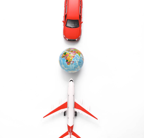 Toy car with air plane and globe on white background. Travel concept. Top view - Photo, Image