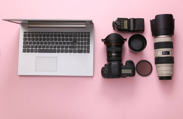 Sada profesionálního fotografického vybavení (kamera s objektivy) s notebookem na růžovém pozadí. Horní pohled. Plocha - Fotografie, Obrázek