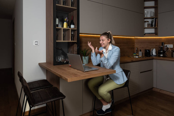 Businesswoman working online, wearing suit and pajamas. Young woman having video call. Business person working at home in lower part of sweatpants and formal wear up. - Fotografie, Obrázek