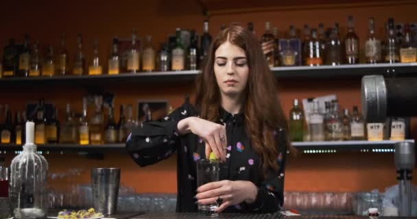 Rothaarige Mädchen. Junge erwachsene Barkeeperin mixt blutigen Mery-Cocktail an der Bar. - Filmmaterial, Video