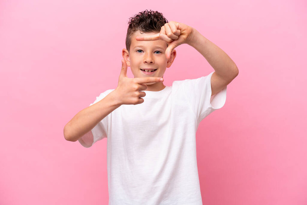 Little caucasian boy isolated on pink background focusing face. Framing symbol - Foto, Imagem