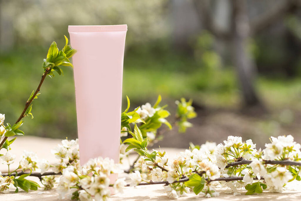 sağlıklı güzellik spa tıbbi cilt konsepti kozmetik losyon kremi şişesi ambalaj tüpü beyaz dekor arka planda çiçek ağacı dalı ile. - Fotoğraf, Görsel