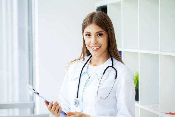 Медична красива жінка-лікар у білому пальто зі стетоскопом
 - Фото, зображення
