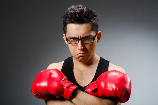 Boxeador divertido con guantes rojos sobre fondo oscuro - Foto, Imagen