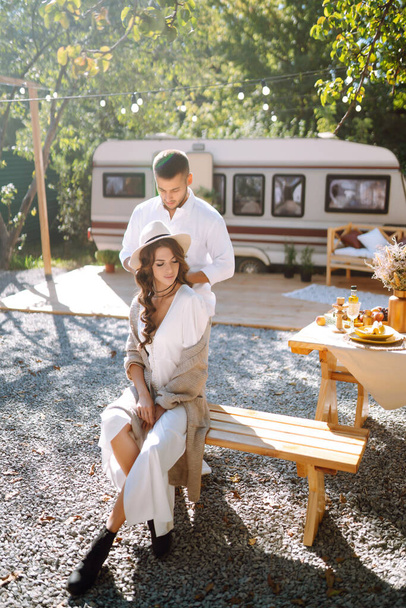 Beautiful wedding couple laugh and kiss relaxing in rv, camping in a trailer. Romantic moment. Together. Wedding. Marriage. - Фото, изображение