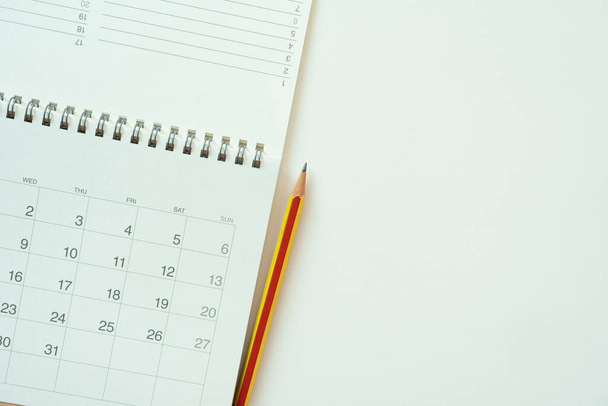 close up of calendar and pencil on the white table background, planning for business meeting or travel planning concept - Photo, Image