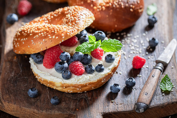 Healthy and sweet golden bagels with berries, and cottage cheese. Bagels with spring and healthy ingredients. - Fotografie, Obrázek