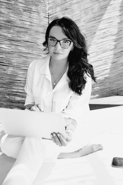 Retrato monocromático de mujer hermosa empresaria, freelancer en gafas de trabajo de forma remota. Educación, viajes, concepto empresarial  - Foto, imagen