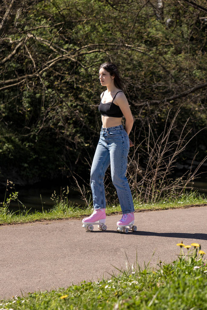 brunette woman skating in the park with pink roller skates - Фото, зображення