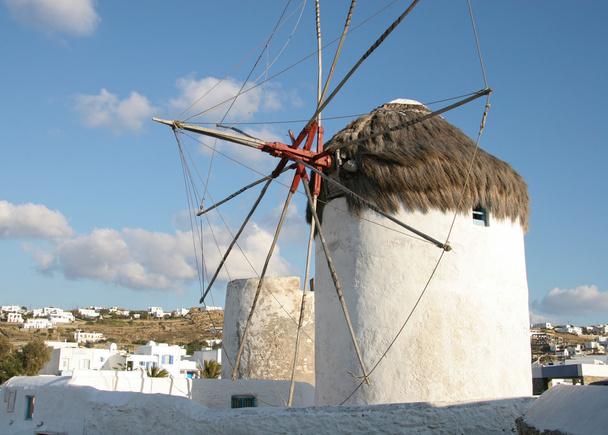 Moulin à vent traditionnel à flanc de colline avec maisons blanchies à la chaux
 - Photo, image