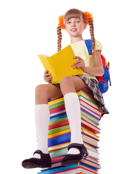 Schoolgirl sitting on pile of books. - Photo, Image