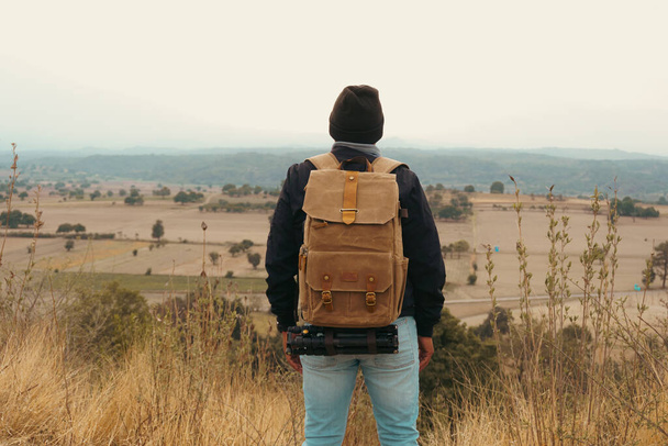 young man wearing jacket and backpack on trek trip outdoor in mountains - Photo, Image