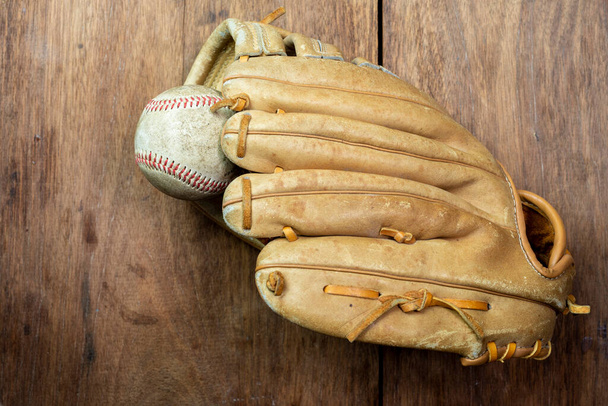 Винтажная классическая кожаная бейсбольная перчатка на деревянном фоне - Фото, изображение
