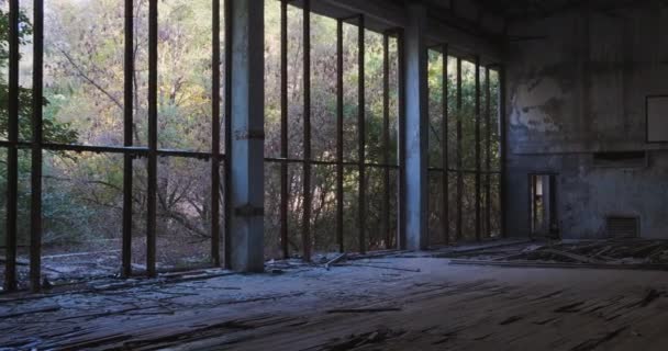 Εγκαταλελειμμένο και κατεστραμμένο από το γυμναστήριο του χρόνου στη ζώνη αποκλεισμού του Pripyat. Καταστροφή Τσερνόμπιλ, πόλη φάντασμα. Δέντρα πίσω από τα σπασμένα παράθυρα του διαδρόμου. Υψηλής ποιότητας 4k πλάνα - Πλάνα, βίντεο