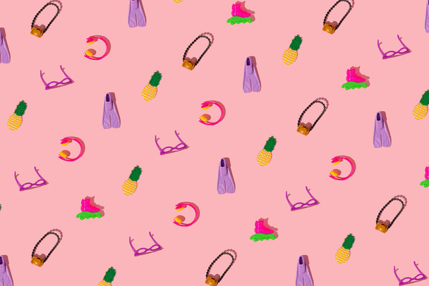 Creatief patroon is gemaakt van damesaccessoires op een roze achtergrond. Minimaal zomerreisconcept. Poppenkunst. - Foto, afbeelding