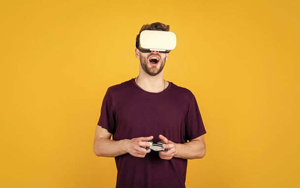 Se on niin todellista. virtuaalisen tietokonepelin pelaaminen verkossa. Nuori mies VR-laseissa. uusi teknologia ja innovaatiot. Mies langattomissa kuulokkeissa. Hän käyttää nykyaikaista teknologiaa. digitaalinen tulevaisuus. - Valokuva, kuva