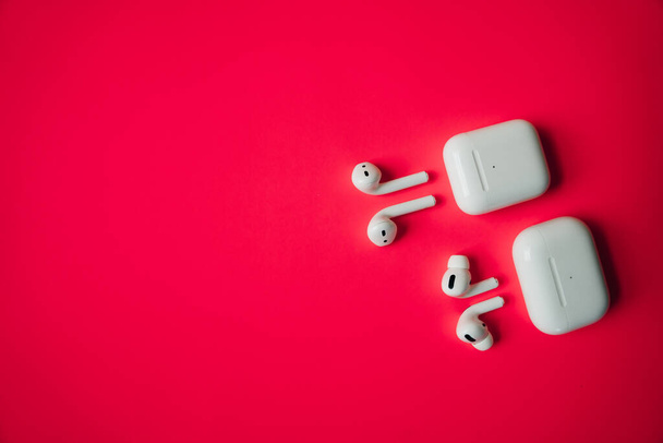 Λευκά ακουστικά με θήκη ασύρματης φόρτισης. Νέα Airpods 2019-2020 σε μαύρο φόντο. Γυναικεία και αντρικά ακουστικά. Αντιγραφή χώρου. Τηλέφωνο. Καναδάς - Μάιος, 2022 - Φωτογραφία, εικόνα