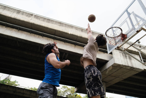 Kaksi valkoihoista miestä pratice koripallo oikeudessa kaupunkien kadulla. - Valokuva, kuva