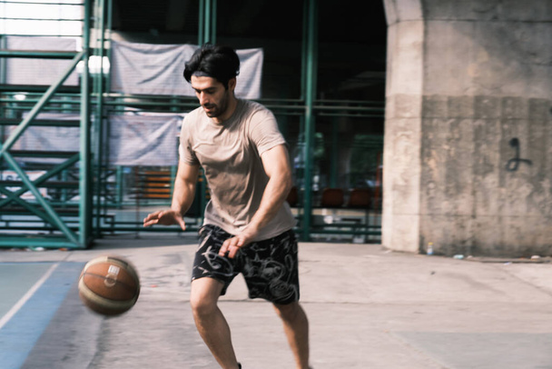 Jonge Kaukasische basketbalspeler schietbal op het straatveld. - Foto, afbeelding