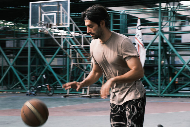 Young causian basketball player shooting ball on street court. - Fotografie, Obrázek