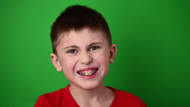 Çocuk gülümsüyor, dişlerini diş plakası ve diş bakımıyla hizalıyor. yeni - Video, Çekim