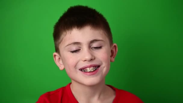 Chlapec se usmívá, zarovnává si zuby se zubní destičkou, zubní péčí. nový - Záběry, video