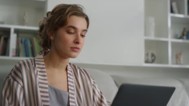 Az alvó menedzser otthon dolgozik laptoppal. Fáradt nő ásít otthon közelről. Gyönyörű fiatal hölgy szőke szabadúszó létre cikket gépelés számítógép távoli munkahelyen. A munkavállalói túlóra fogalma - Felvétel, videó