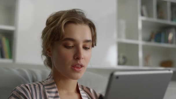 閉鎖マネージャーはパジャマの離れた職場でタブレットデジタルコンピュータを保持しています。若い自信のある女性はリビングルームでパッド上でオンライン決済銀行を作る。魅力的なブロンドフリーランサー仕事かむ唇 - 映像、動画