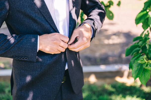 Joven hombre guapo elegante vestido con ropa formal moderna chaqueta abotonadora. Persona lista para la celebración de la boda o la graduación. - Foto, Imagen