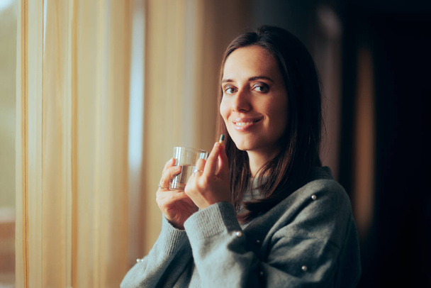Smiling Woman Holding a Glass of Water Taking a Pill - Φωτογραφία, εικόνα