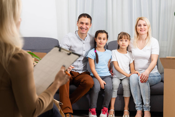 Mano di uno psicoterapeuta di famiglia professionista che scrive appunti di fronte a una famiglia con un bambino durante una consultazione. - Foto, immagini