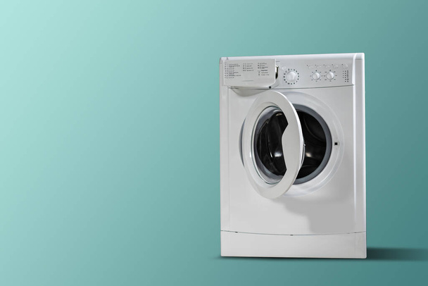 Clothes washing machine in laundry room interior on blue wall, copy space - Φωτογραφία, εικόνα