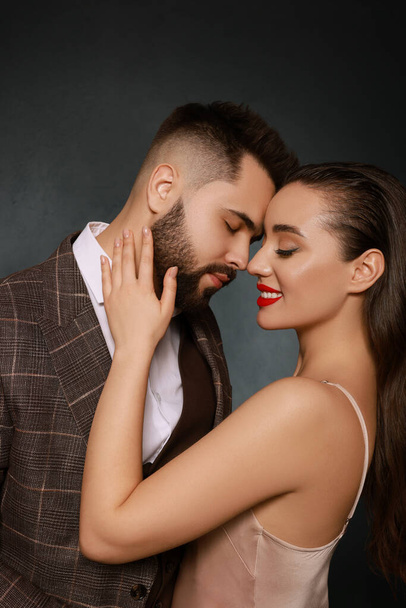 Handsome bearded man with sexy lady on grey background - Foto, imagen
