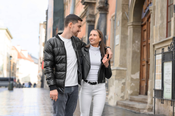 Lovely young couple walking together on city street. Romantic date - Фото, изображение