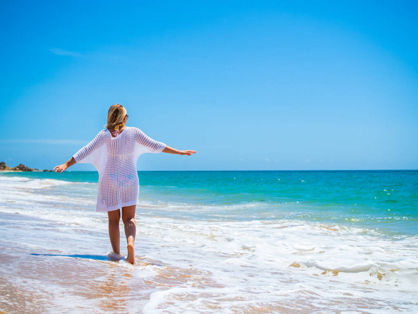 Woman walking on sunny beach - Photo, Image