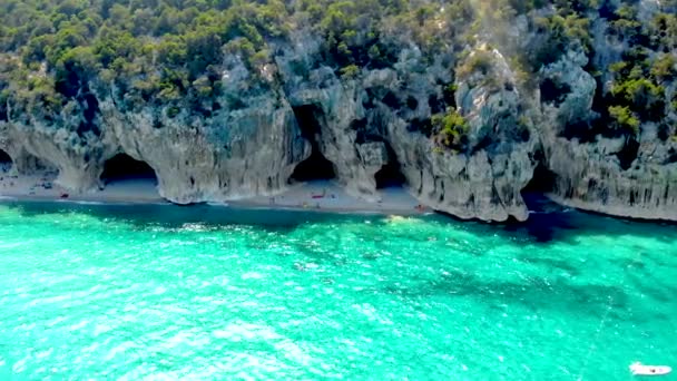 Golfo di Orosei Sardina, Вид згори, вражаючий вигляд на пляж повний парасольок і людей, що купаються і плавають у бірюзовій воді. Кала Гононе, Сардинія, Італія, Кала Маріолу. - Кадри, відео