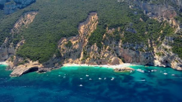 Golfo di Orosei Sardina, Вид згори, вражаючий вигляд на пляж повний парасольок і людей, що купаються і плавають у бірюзовій воді. Кала Гононе, Сардинія, Італія, Кала Маріолу. - Кадри, відео