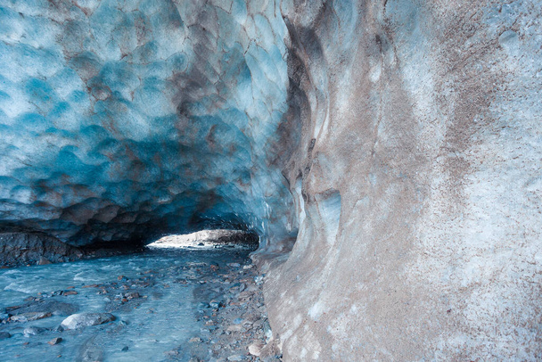 Kék barlangot véstek a Vallelunga gleccser jegébe egy patak keresztezte. A gleccser gyorsan visszavonul a globális felmelegedés miatt, Alto Adige, Olaszország - Fotó, kép