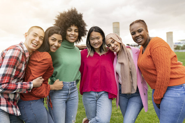 Gruppe fröhlicher multirassischer junger Freundinnen, die sich im Park umarmen - Konzept von Studentinnen aus der ganzen Welt - - Foto, Bild