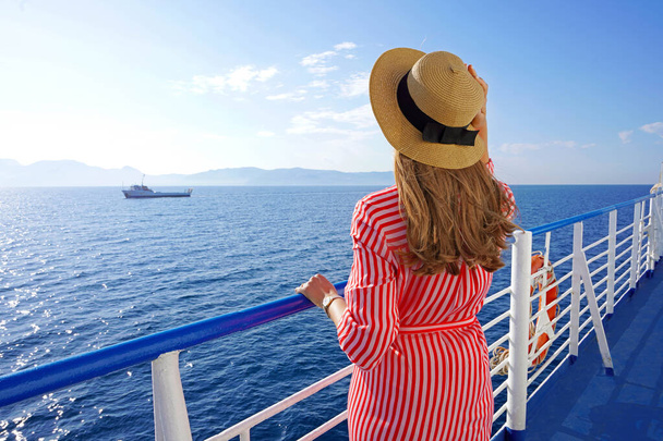 Vakantie met cruiseschepen. Achteraanzicht van ontspannen mode vrouw genieten van reizen op cruiseschip. - Foto, afbeelding