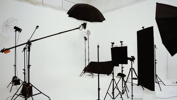 Studio video production lighting set. Behind the scenes shooting production set up by crew team camera and equipment in studio. Video production filming or commercial movie film live streaming online. - Фото, зображення