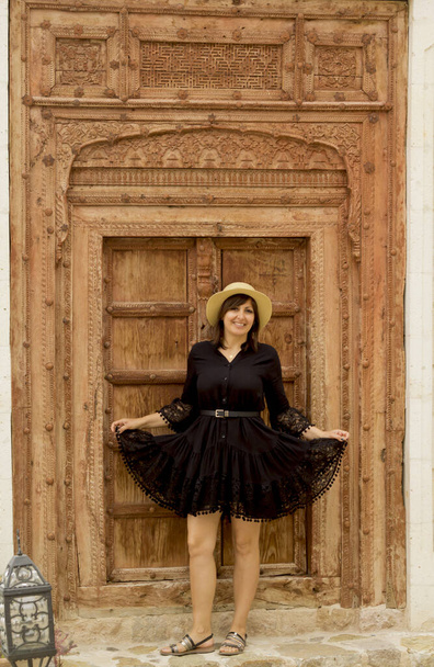 beautiful young woman in a hat standing front of the door in cappadocia, turkey - Fotó, kép