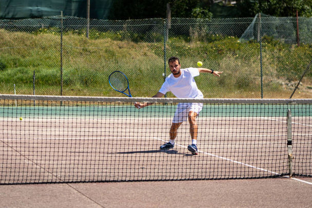 Tennis player performing a drop shot on court. - Foto, Imagen