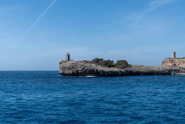 cliffs with lighthouse near porto cristo - 写真・画像