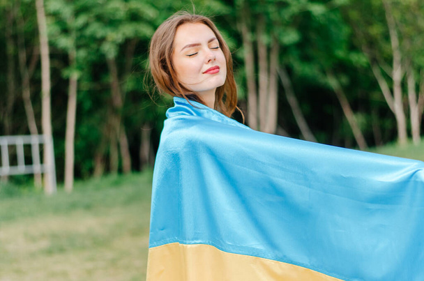 Mulher ucraniana com a bandeira da Ucrânia. Menina com a bandeira da Ucrânia. Bandeira da Ucrânia. Ucrânia. Foto patriótica de uma menina com uma bandeira azul e amarela da Ucrânia - Foto, Imagem