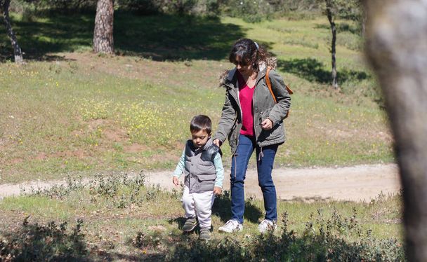 Moeder met haar zoon wandelen op het platteland terwijl op zoek naar caches - Foto, afbeelding