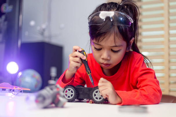 Gli studenti asiatici imparano a loro agio nella codifica di robot e cavi elettronici in STEM, STEAM, ingegneria matematica, ingegneria, tecnologia, codice informatico in robotica per bambini concetto. - Foto, immagini