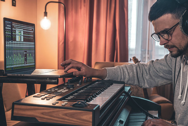 Чоловічий музикант грає музичні клавіші в навушниках, концепція створення музики
. - Фото, зображення