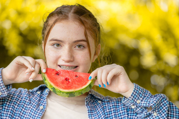 bela menina adolescente sorrindo com melancia e dentista tratamento ortodôntico dentes alinhados com aparelhos ou alinhadores - Foto, Imagem