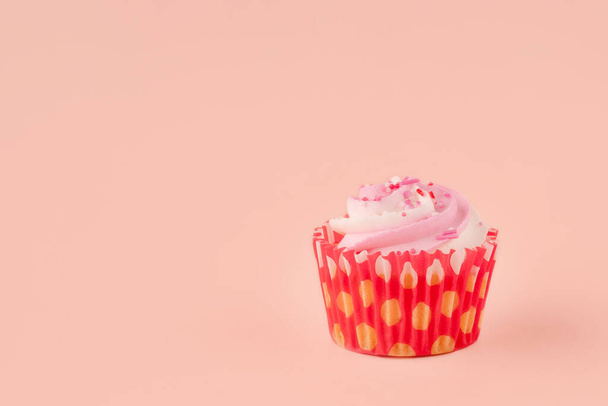muffin aux baies dans des emballages rouges sur un fond rose photos de haute qualité pour calendrier et cartes. Espace pour le texte - Photo, image
